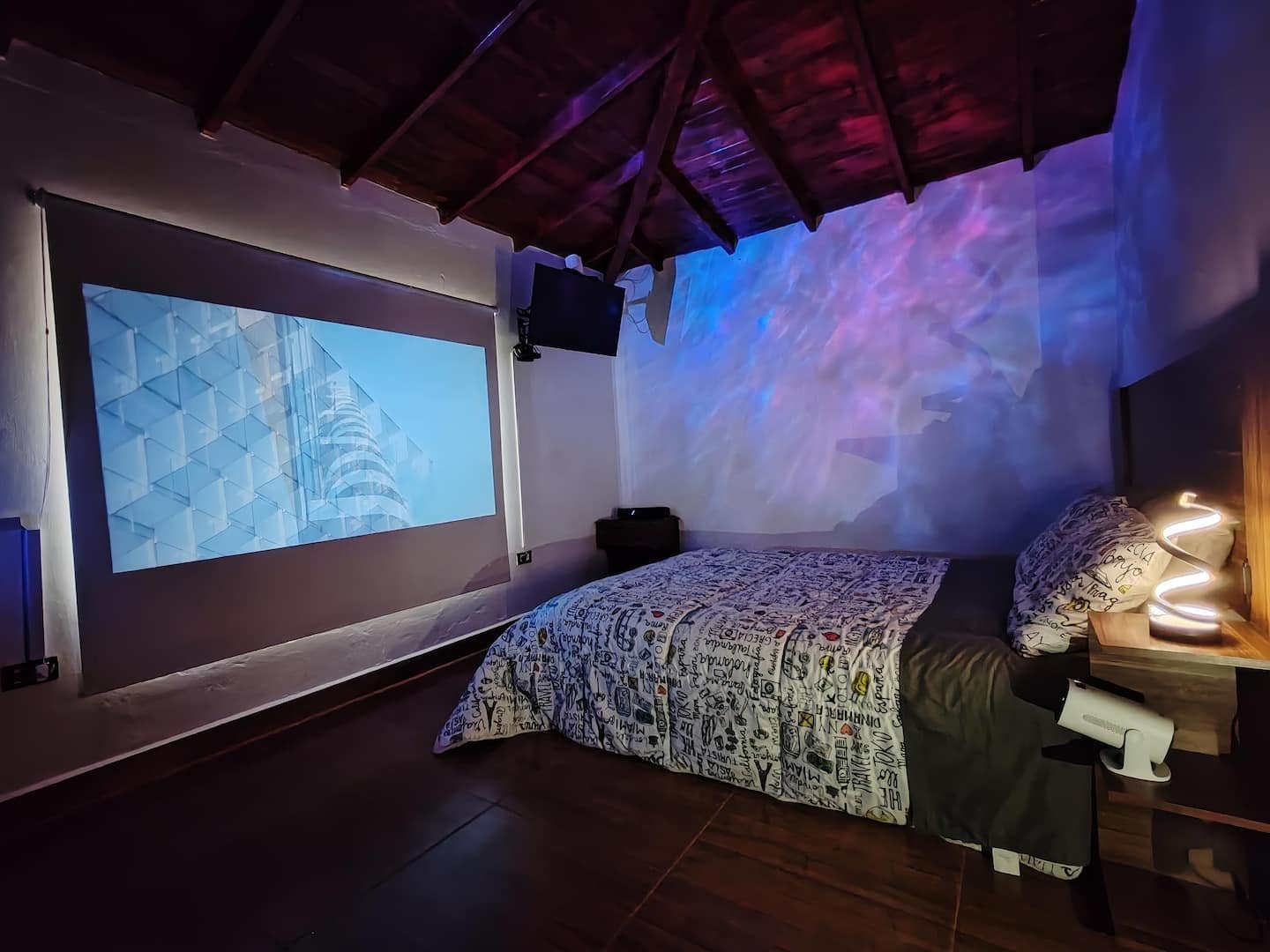 Suite Campestre de noche, con el proyector tipo cine encendido y el techo en madera